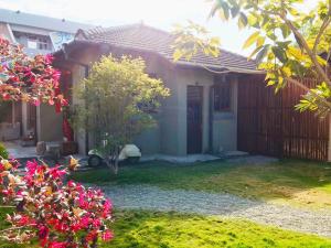屏東市的住宿－勝利文旅日式民宿，一座小房子,带粉红色花的院子