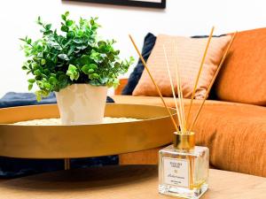 a table with a potted plant and a bottle of perfume at 2bdr Luxury Fully Equipped Prime Location in Sofia