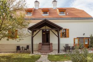 uma casa branca com um telhado castanho em Köveskál Panzió em Köveskál