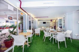 a restaurant with white chairs and tables and grass at Hotel White Grand Shimla-near ISBT bus stand in Shimla