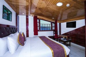a bedroom with a bed and a tv in a room at Hotel White Grand Shimla-near ISBT bus stand in Shimla