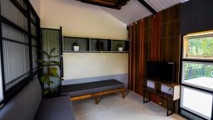 a living room with a bench and a tv at Silent Planet Resort in Koroth