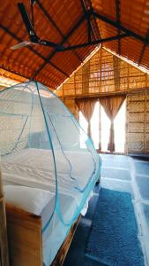 een groot bed in een kamer met een plafond bij Osho's Organic Resort Hampi in Hampi