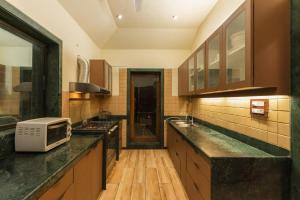 a kitchen with a sink and a microwave on a counter at Pawna By Hangout Villas in Lonavala