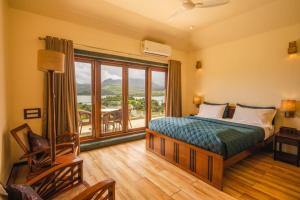 a bedroom with a bed and a large window at Pawna By Hangout Villas in Lonavala