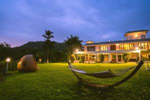 a hammock in a yard in front of a building at Pawna By Hangout Villas in Lonavala