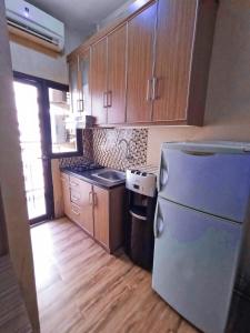 una cucina con frigorifero, piano cottura e armadietti di Apartemen evenciio a Pondoktjina 1