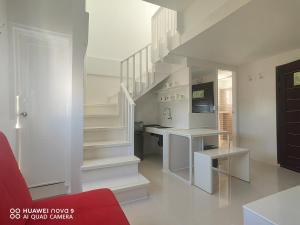 a white kitchen with stairs and a red couch at Mecasa Hotel in Boracay