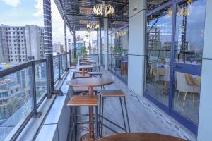 a row of tables on the roof of a building with windows at South Gate Hotel Apartment in Addis Ababa