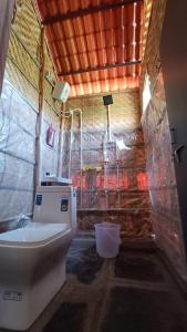 bagno con servizi igienici in una camera con parete di Osho's Organic Resort Hampi a Hampi