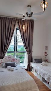 a bedroom with two beds and a window at The Healing Homestay Putrajaya in Putrajaya