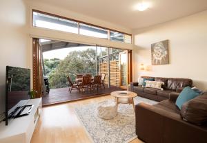 een woonkamer met een bank en een tafel bij Dunes Villa South Shores Normanville walk to beach in Normanville