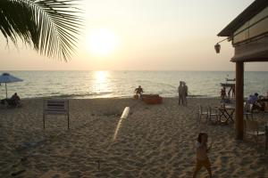 a group of people on the beach at sunset at Duong Hieu Guesthouse in Phu Quoc