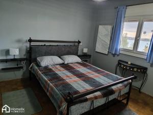 a bedroom with a bed with a checkered blanket at Άνετο και ήσυχο διαμέρισμα με θέα in Chalkida