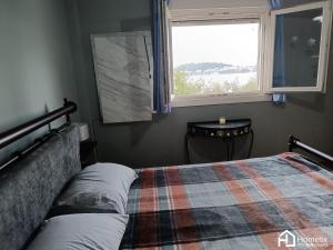 Schlafzimmer mit einem Bett und einem Fenster in der Unterkunft Άνετο και ήσυχο διαμέρισμα με θέα in Chalkida