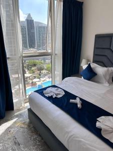 a bedroom with a bed with a view of a pool at Dunya Tower Luxury and 2 min walk to Dubai Mall and Burj Khalifa in Dubai