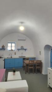 a kitchen and dining room with a table and blue cabinets at Kamaraki Aroniadika in Kythira