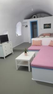 a bedroom with two beds and a desk and a laptop at Kamaraki Aroniadika in Kythira