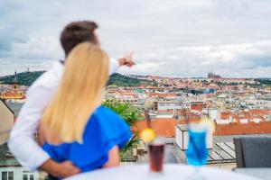 un hombre y una mujer mirando hacia una ciudad en Wenceslas Square Hotel - Czech Leading Hotels en Praga