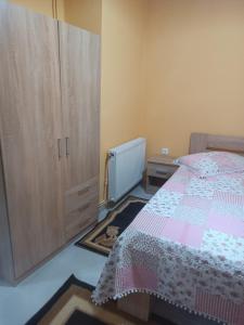 a bedroom with a bed and a large cabinet at Kipseli 1 in Kozani