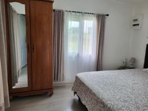 a bedroom with a dresser and a bed and a window at Case Créole Soalaze in Salazie