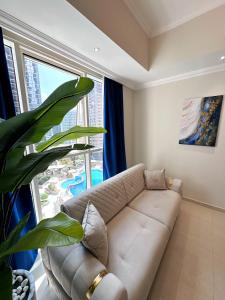 a living room with a couch and a large window at Dunya Tower Luxury and 2 min walk to Dubai Mall and Burj Khalifa in Dubai