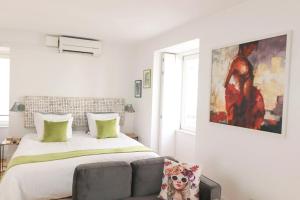 a bedroom with a bed with a couch and a painting at Boutique Apartment in the Heart of Lisbon ! Lemonn B in Lisbon