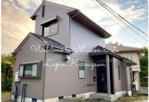 a gray house with a black door at Maison Petit Lapin メゾンプチラパン in Karuizawa +32 photos
