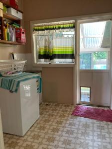 uma cozinha com um frigorífico branco e uma janela em Do Drop Inn 188 Clarke St east, CAREY PARK W A em Carey Park