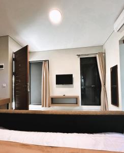 um quarto com uma cama grande e uma televisão em Apartment Nawasena em Sanur