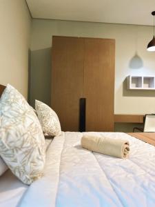 uma cama branca com uma toalha enrolada em Apartment Nawasena em Sanur