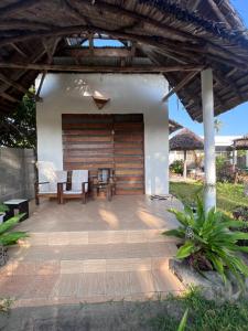 a patio with a table and chairs under a pergola at New Dindini Lodge in Kilindoni