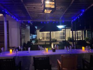 New Dindini Lodge في كيليندوني: طاولة بيضاء طويلة في مبنى به أضواء زرقاء
