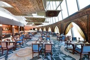 فندق الشعلة (ذا تورش) الدوحة في الدوحة: غرفة طعام مع طاولات وكراسي ونوافذ