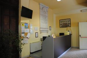 ein Büro mit einer Rezeption und einem TV an der Wand in der Unterkunft Sacro Cuore Hotel in Massa