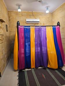 een podium met kleurrijke gordijnen in een kamer bij Hotel Royal Haveli in Jaisalmer