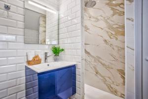 uma casa de banho com um lavatório azul e um espelho. em La Maison de Pêcheur de Ginette em Cabourg