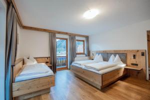 um quarto com 2 camas e uma grande janela em Karlingerhof em Achenkirch