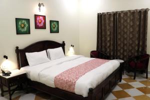 a bedroom with a large bed and two chairs at Hotel Fort Padmawati in Pratāpgarh