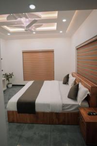 um quarto com uma cama grande e uma cabeceira em madeira em Beverly hills holiday homes em Vythiri