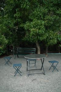 una mesa de picnic y dos sillas frente a un árbol en Beverly hills holiday homes, en Vythiri