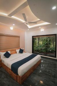 1 dormitorio con cama grande y ventana grande en Beverly hills holiday homes, en Vythiri