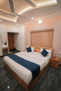 um quarto com uma cama grande e almofadas azuis em Beverly hills holiday homes em Vythiri