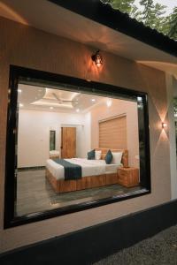 um reflexo de um quarto com uma cama num espelho em Beverly hills holiday homes em Vythiri