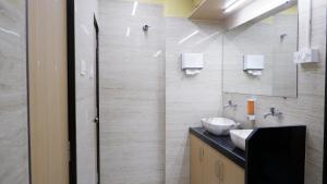 a bathroom with two sinks and a mirror at Astropods in Mumbai