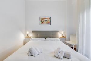 a white bedroom with a large white bed with two pillows at Ciampino Luxe -15min Termini, Airport and Train Station - in Ciampino +9 photos