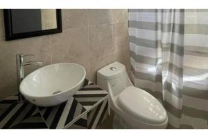 a bathroom with a white toilet and a sink at OYO Hotel Puerta Sur in Comitán