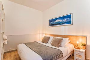 - une chambre avec un lit et une photo sur le mur dans l'établissement La Maison de Pêcheur de Ginette, à Cabourg