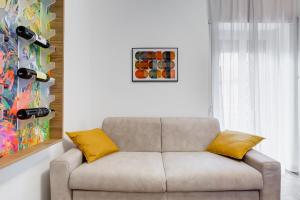 a living room with a couch with yellow pillows at Ciampino Luxe -15min Termini, Airport and Train Station - in Ciampino