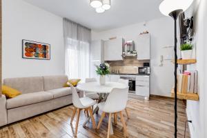 uma sala de estar com um sofá, uma mesa e cadeiras em Casa Vacanze Ciampino airport and train station em Ciampino